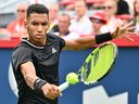 Montreal's Félix Auger-Aliassime hits a return agains Casper Ruud of Norway during quarter-final action at IGA Stadium on Friday.