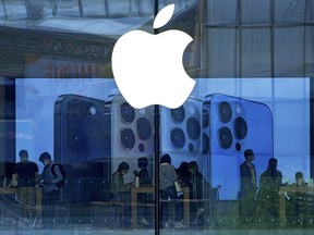 People shop at an Apple Store in Beijing, Tuesday, Sept. 28, 2021.