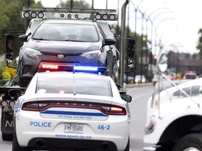 Montreal police seize cars near the scene of a shooting Aug. 12, 2022. A 25-year-old woman was injured in the east end shooting.