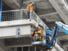 Construction workers  at a downtown Montreal site Tuesday, Feb. 9, 2021.