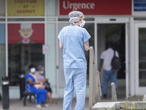 A healthcare worker is shown outside a hospital in Montreal, Thursday, July 14, 2022, as the COVID-19 pandemic continues in the province. Over 7000 healthcare workers are off the job due to COVID-19 related reasons.