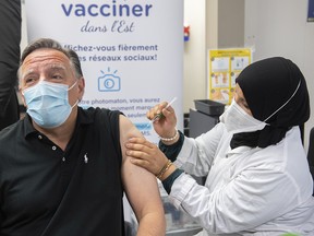 Premier François Legault receives a COVID-19 booster vaccine dose from Kenza Kias in Montreal, Friday, August 5, 2022. "It was hard for me not to notice that the person giving him the shot happened to be a hijab-wearing woman," Fariha Naqvi-Mohamed writes.