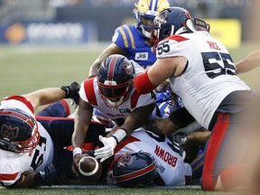 Alouettes quarterback Dominique Davis reaches across the goal line for a short-yardage touchdown during the first half against the Blue Bombers Thursday night at IG Field.