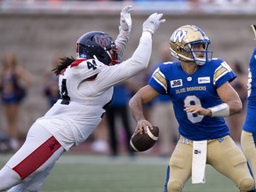 Montreal Alouettes defensive lineman Mike Moore pounces on Winnipeg Blue Bombers quarterback Zach Collaros during first quarter CFL football action in Montreal on Thursday, August 4, 2022.