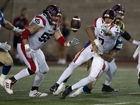 Montreal Alouettes quarterback Trevor Harris tries a lateral pass as he is tackled by Winnipeg Blue Bombers defensive end Jackson Jeffcoat during second quarter CFL football action in Montreal on Thursday, August 4, 2022.