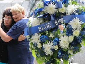 Marlie Wirtanen (right) and Linda Nagy embrace in Philips square in Montreal Friday, August 31, 2012 where a memorial was unveiled for 37 victims who died in a fire at the Blue Bird cafe 40 years ago. Linda was a survivor of the fire and Marlie's sister Kathy died in the fire Sept. 1,1972.