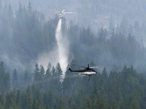 Helicopters drop water on the Christie Mountain wildfire along Skaha Lake in Penticton, B.C. on Friday, Aug. 21, 2020.