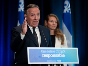 Coalition Avenir Québec Leader François Legault speaks about finances and tax reduction at a news conference during a campaign stop in Quebec City, Monday, August 29, 2022. CAQ candidate Joelle Boutin, right, looks on.