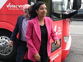 Quebec Liberal Leader Dominique Anglade walks from her campaign bus to at a news conference, Wednesday, August 31, 2022  in St-Agapit, Que. Local candidate Normand Côté follows.