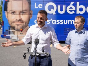 Parti Québécois Leader Paul St-Pierre Plamondon introduces Raphael Fievez, who was ousted as a candidate for Québec solidaire, during a campaign stop in Montreal on Wednesday. Fievez will work on the PQ campaign.