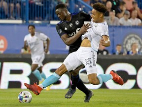 CF Montréal midfielder Victor Wanyama, rear, and New England Revolution defender Brandon Bye battle for the ball during the first half at Saputo Stadium on Aug. 20, 2022.