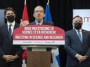 Premier François Legault, right, and Prime Minister Justin Trudeau look on as Moderna CEO Stéphane Bancel speaks during an announcement of the opening of a Moderna vaccine production and research facility in the Montreal area, Friday, April 29, 2022.