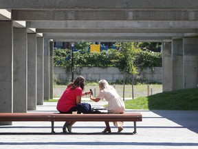 Two people share a moment at Viger Sqare in August.