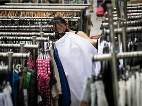 A shopper checks out what's on offer during a sidewalk sale on St-Laurent Blvd. in August 2021.