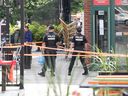 Montreal police at a crime scene on St-Denis St. on Aug. 23, where a man was shot and killed in a restaurant 30 minutes after a man was shot and killed at the Rockland shopping centre in T.M.R.