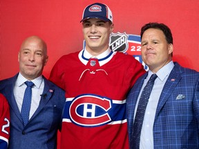 Kent Hughes (vľavo) pozdravuje Juraja Slavkowského s Jeffom Gortonom ako prvú voľbu tímu Montreal Canadiens počas draftu NHL v Montreale 7. júla 2022.