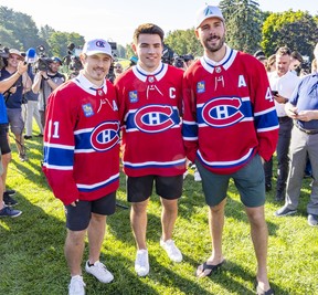 Nick Suzuki stops for a picture after being named the new captain of the Montreal Canadiens with assistant captains Brendan Gallagher, left, and Joel Edmundson at the team's annual golf tournament in Laval on Sept. 12, 2022.