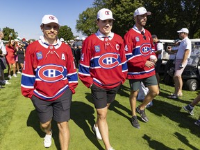 Montreal Canadiens Nick Suzuki is flanked by assistant captains Joel Edmondson, right, and Brendan Gallagher after being named the team's latest captain at their annual golf tournament in Laval on Sept. 12, 2022.