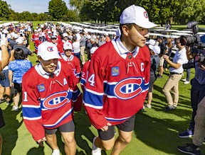 Nick Suzuki leads his Montreal Canadiens team-mates after being named the team's new captain at their annual golf tournament in Laval on Sept. 12, 2022.  Assistant captain Brendan Gallagher follows at left.