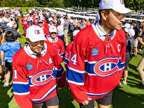 Nick Suzuki, right, and Brendan Gallagher show off their new Canadiens jerseys, which feature 3x3.5-inch RBC patches, Monday in Laval.