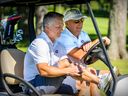 Montreal Canadiens coach Martin St. Louis, left, shares a cart with general manager Kent Hughes at the team's annual golf tournament in Laval on September 11, 2022.