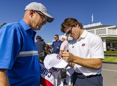 Cole Caufield signs an autograph for Jean-Francois Prince at the Montreal Canadiens' annual golf tournament in Laval on Sept. 12, 2022.