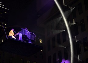 Ariane Moffatt plays piano on a stage lifted to the centre of the ring during an event to mark the 60th anniversary of Place Ville Marie, in Montreal, on Wednesday, Sept. 14, 2022.