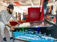 Gursagar Singh plays pinball in his recently opened arcade in Ste-Anne-de-Bellevue.