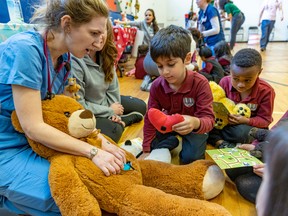 First grade student Mahdiyar Taghvaee takes a heart from a stuffed bear being held by Edith Corriveau-Parenteau, McGill's fourth year medical student, during the Teddy Bear Hospital event at Hampstead Elementary School on the surgical ward.