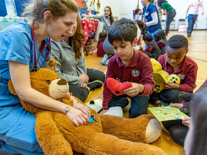  Grade One student Mahdiyar Taghvaee takes a heart from a stuffed bear held by McGill fourth-year medical student Edith Corriveau-Parenteau at the surgical station during the Teddy Bear Hospital event at Hampstead Elementary School.