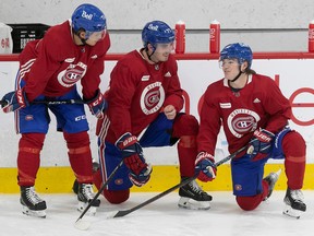 Montreal Canadiens' Kirby Dach is flanked by Jake Evans, left, and Cole Caulfield during first day of training camp in Brossard on Sept. 22, 2022.