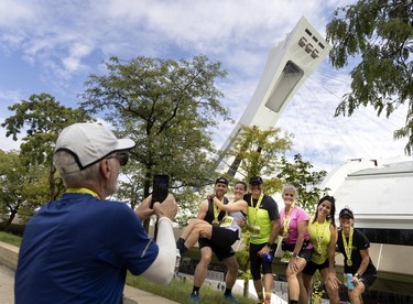 A group of runners take pictures in front of the Olympic Stadium after finishing the Montreal marathon on Sept. 25, 2022.