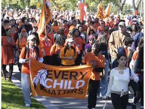 People walk along Parc Ave. during the National Day of Truth and Reconciliation march held in Montreal on Friday, Sept. 30, 2022.