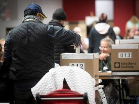 voter puts a ballot in a ballot box