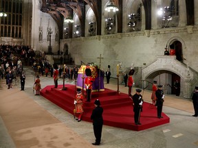 People observe a "National moment of reflection" in honour of the late Queen Elizabeth before they file past the coffin of Queen Elizabeth II during the lying in state at Westminster Hall on Sunday, Sept. 18, 2022, in London.