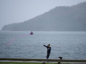 A man flies a kite along the Canso Causeway as wind and rain from post-tropical storm Fiona hits the region Sept. 24, 2022 in Port Hastings, N.S.