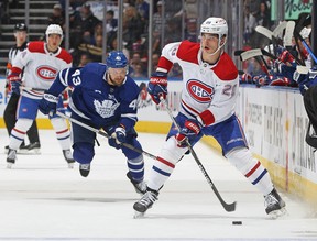 Juraj Slafkovsky of the Montreal Canadiens drives the puck against Kyle Clifford of the Toronto Maple Leafs during an NHL preseason game at Scotiabank Arena in Toronto on Wednesday, September 28, 2022.