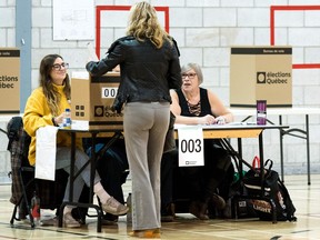 A woman casts her ballot at a polling station in the provincial elections on October 1, 2018 in Montreal,  Quebec.