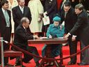 Queen Elizabeth II signs Canada's constitutional proclamation in Ottawa on April 17, 1982 as Prime Minister Pierre Trudeau looks on. It was her signature that enshrined inalienable rights into our Constitution, her presence that sparked so much excitement, Allison Hanes writes.