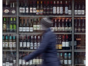 A customer walks past shelves of bottles of alcohol on display at an LCBO in Ottawa.