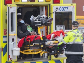 Paramedics transfer a person from an ambulance into a hospital, amid the global COVID-19 pandemic, in Montreal, Saturday, Dec. 18, 2021.