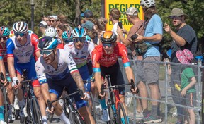 Fans watch as riders in the Grand Prix Cyclistes race speed by in Montreal on Sept. 11, 2022.