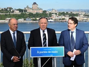 Coalition Avenir Québec Leader François Legault unveils his program on health Friday, September 2, 2022 in Lévis, flanked by candidates Christian Dubé, left, and Bernard Drainville.