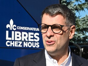 Quebec Conservative Leader Eric Duhaime chats with candidates outside his campaign bus, Saturday, Sept. 17, 2022 in Levis Que. Quebecers are going to the polls for a general election on Oct. 3.