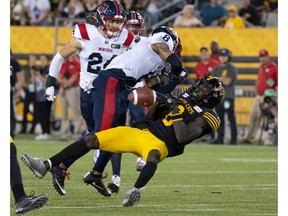 Hamilton Tiger-Cats wide-receiver Steven Dunbar Jr. loses the ball after being hit by Montreal Alouettes cornerback Mike Jones during second half in Hamilton on July 28, 2022.