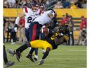 Hamilton Tiger-Cats wide receiver Stephen Dunbar Jr. lost the ball after being hit by Montreal Alouette cornerback Mike Jones in the second half of the game in Hamilton on July 28, 2022.