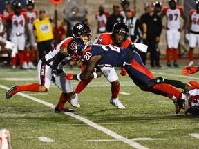 Montreal Alouettes' Jeshrun Antwi (20) is tackled by Ottawa Redblacks defensive-back Abdul Kanneh (14) during the second quarter at Molson Stadium in Montreal on Sept. 2, 2022