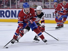 Montreal Canadiens forward Cole Caufield plays the puck as New Jersey Devils forward Andreas Johnsson defends during the first period at the Bell Centre on Monday, Sept. 26, 2022.