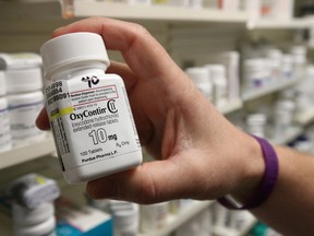 A pharmacist holds a bottle OxyContin