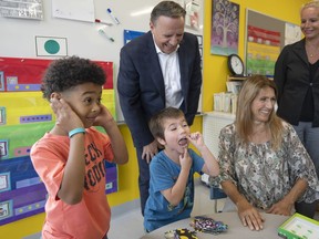 Coalition Avenir du Québec leader François Legault has a laugh with students while campaigning Wednesday, Aug. 31, 2022 in Montreal.